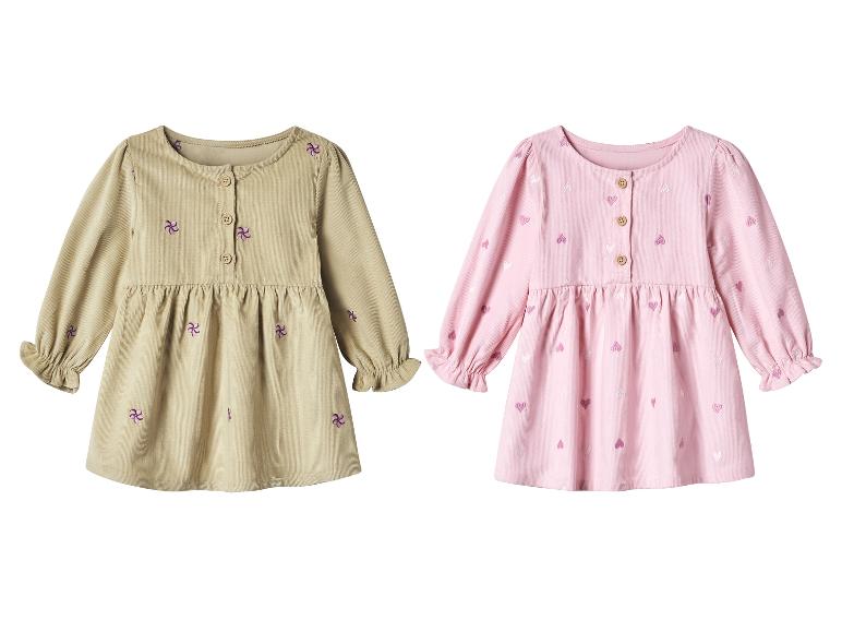 Zwei langärmelige Cordkleider, eines beige mit lila Blumenstickerei und eines rosa mit Herzstickerei.