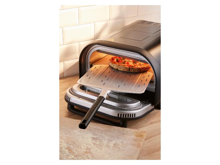 Elektrischer Pizzaofen mit einer Pizza, die mit einem Schieber hineingeschoben wird.