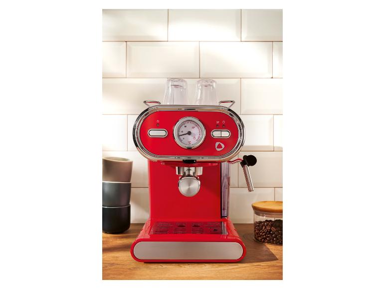 Rote Espressomaschine auf einer Küchenzeile mit Tassen und Kaffeebohnen.