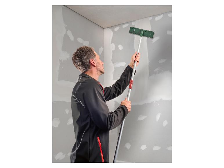 Mann schleift eine Wand mit einem Langstielschleifer.