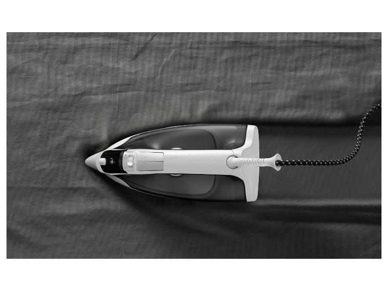 Ein Bügeleisen auf einem dunkelgrauen Stoff, das Falten glättet.