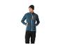 Mann in einer teal- und grauen Fleecejacke mit schwarzer Hose und dunkler Mütze.