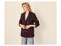 Lächelnde Frau in strukturiertem bordeauxrotem Blazer, weißem T-Shirt und heller Jeans.