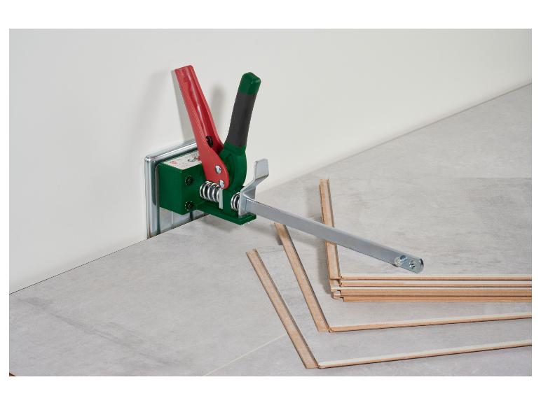 Laminatverlegewerkzeug mit roten und grünen Griffen, auf einem Laminatboden.