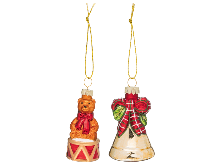 Zwei Weihnachtsbaumschmuckstücke: ein Teddybär auf einer Trommel und eine Glocke mit Schleife.