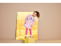 Mädchen in pinker flauschiger Jacke, weißem T-Shirt mit Zeichentrickfiguren und pinkem Glitzerrock.