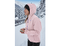 Frau in rosa Jacke und schwarzer Mütze in verschneiter Winterlandschaft.