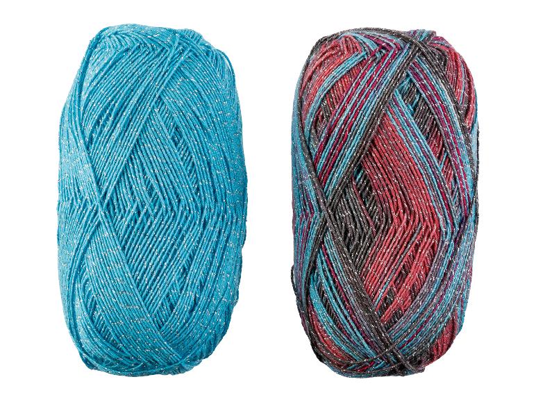 Zwei Garnknäuel, eines türkis und eines mehrfarbig, beide mit silbernem Glitzer.