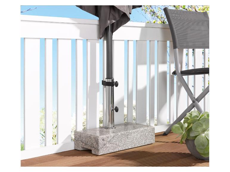 Granit-Sonnenschirmständer auf einer Holzterrasse mit Stuhl und Pflanze.