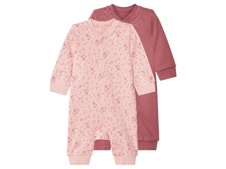Zwei Baby-Strampler, einer rosa mit Sternen und einer einfarbig mauve.