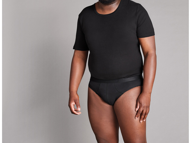Ein Mann trägt ein schwarzes T-Shirt und Unterwäsche.