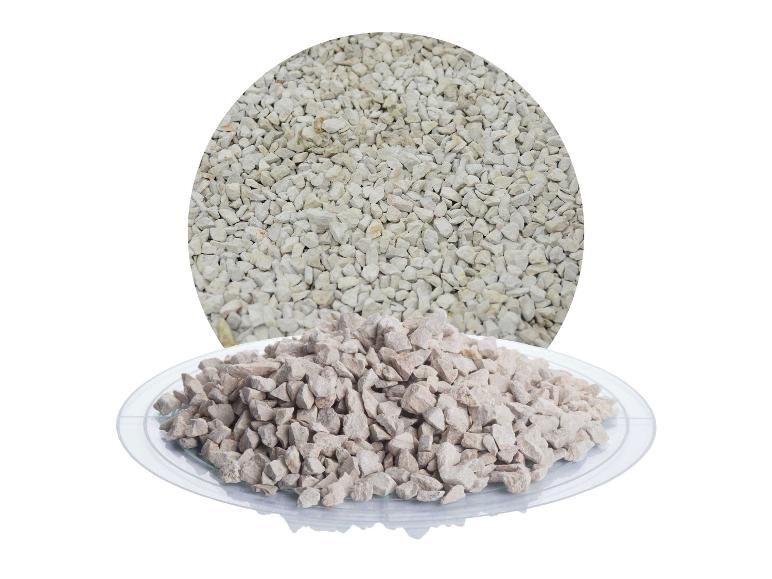 Zwei Haufen heller, zerkleinerter Steine, einer in einem Kreis und einer auf einer Glasplatte.