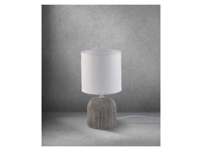 Moderne Tischlampe mit weißem Lampenschirm und grauer Keramikbasis.