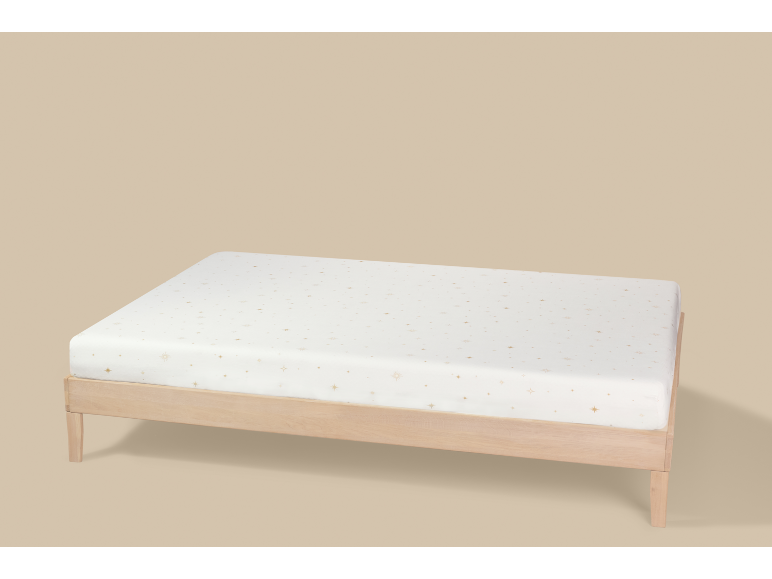 Babymatratze mit Sternenmuster auf einem Holzlattenrost.