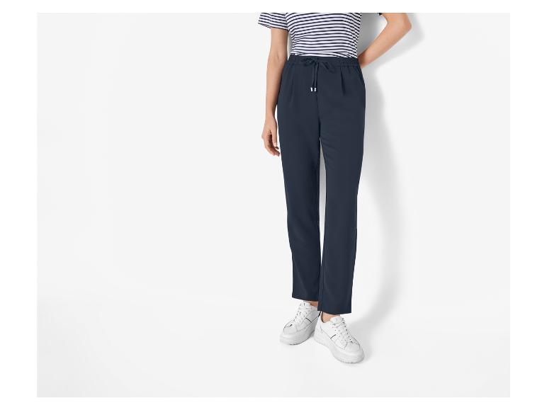 Dunkelblaue Hose mit Kordelzug und weiße Sneaker.