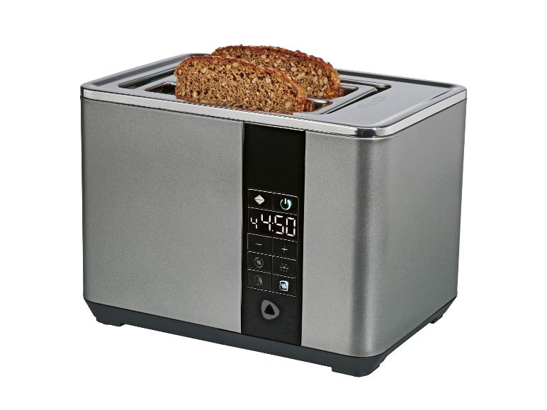 Silberner Toaster mit zwei Schlitzen und Digitalanzeige, mit Brotscheiben darin.