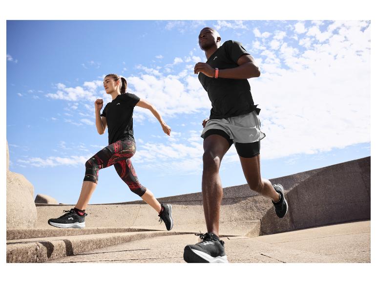 Zwei Personen laufen draußen in schwarzer und grauer Sportkleidung, mit Fitness-Trackern.