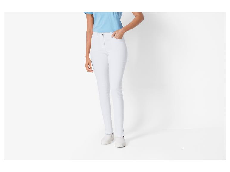 Frau in hellblauem T-Shirt und weißer Hose.