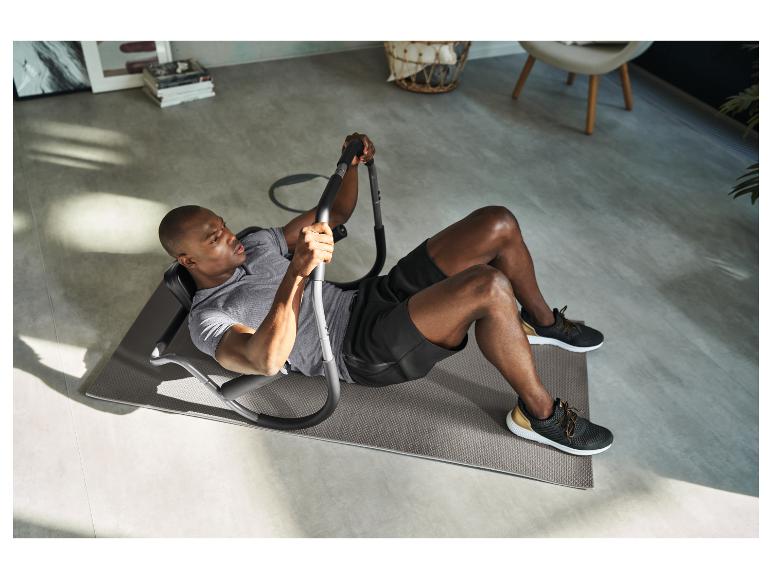 Mann macht Crunches mit einem Bauchtrainer auf einer Fitnessmatte.