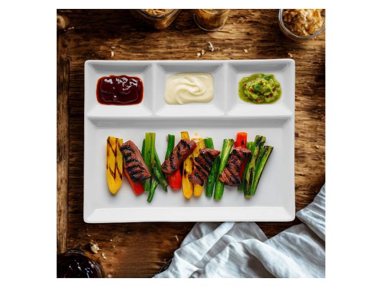 Gegrilltes Fleisch und Gemüse mit drei Saucen auf einem weißen Teller.