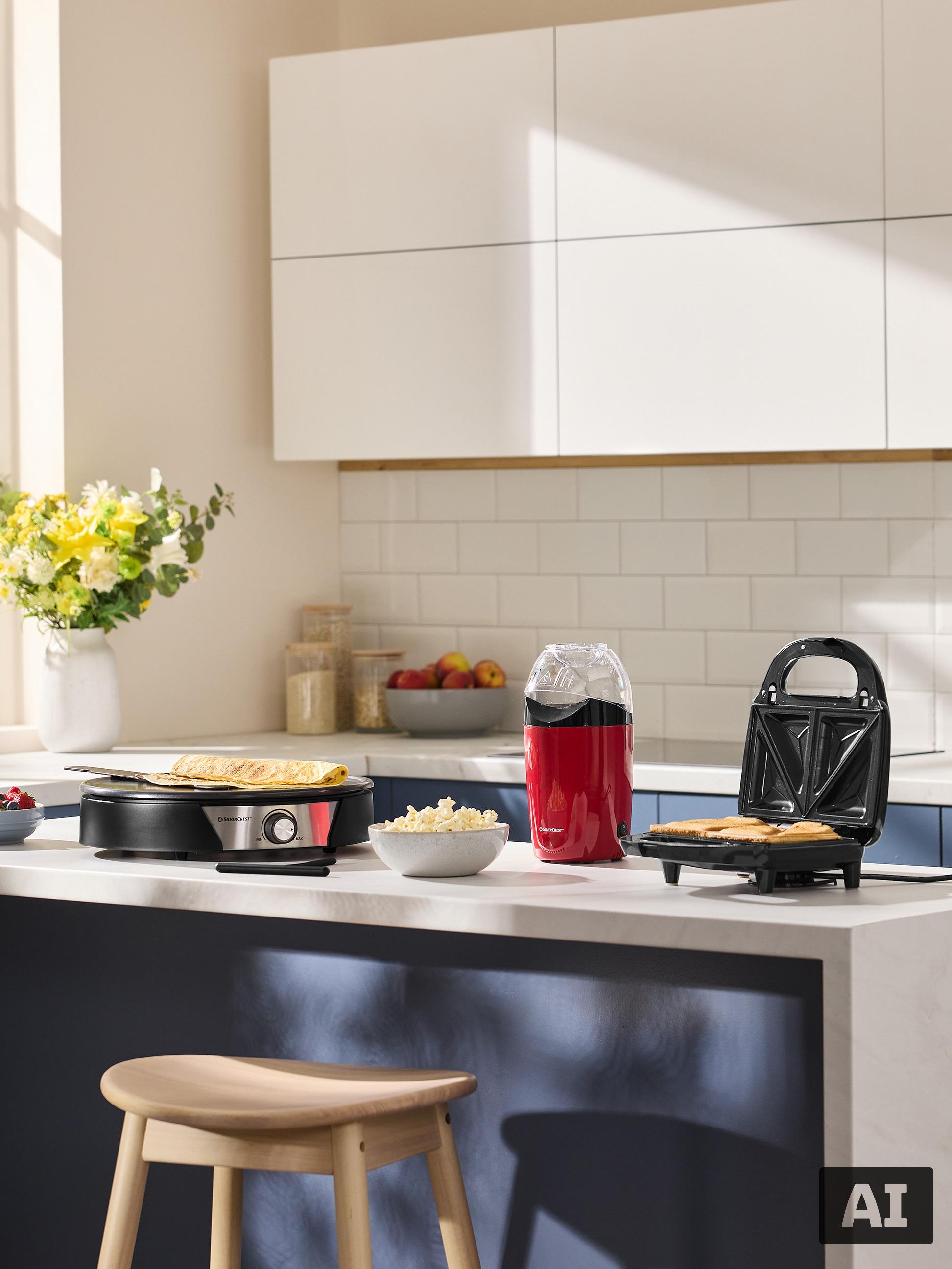 Küche mit Crêpes- und Sandwichmaker sowie Popcornmaschine, bereit für das Frühstück.