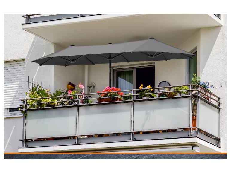 Grauer Doppel-Sonnenschirm auf einem blühenden Balkon