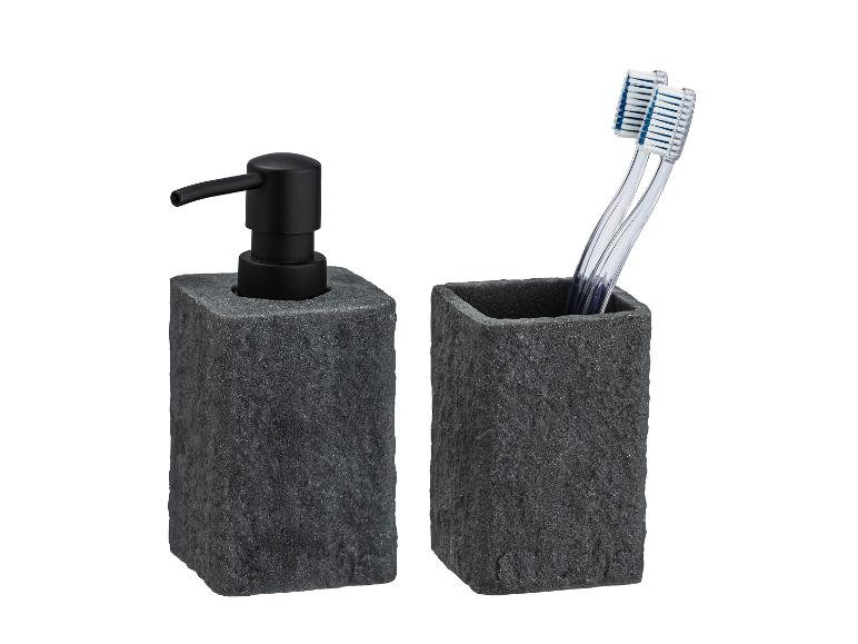 Dunkelgrauer Seifenspender und Zahnbürstenhalter aus Stein.