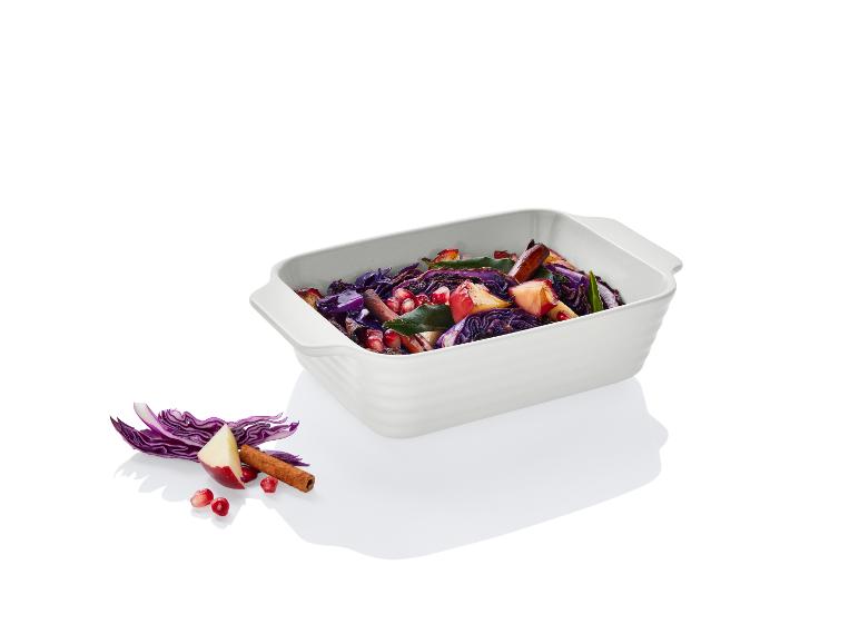 Eine weiße Auflaufform mit Rotkohl, Apfel und Granatapfel.