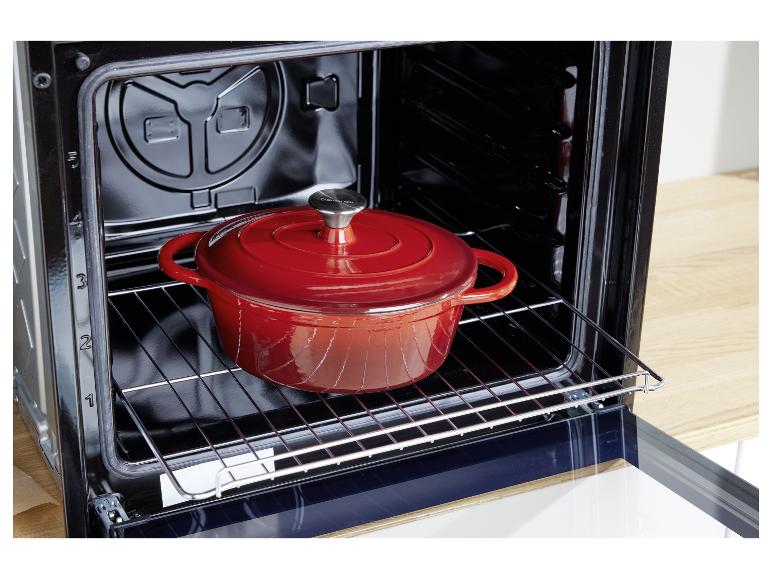 Ein roter Silvercrest Gusseisentopf in einem Ofen.