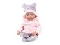 Babypuppe in einem rosa Hoodie und gemusterten Hosen mit passender Mütze.