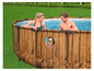 Ein rundes, hölzernes Schwimmbecken mit zwei Erwachsenen und einem Kind.