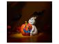 Halloween-Dekoration mit Geist-Figur und geschnitztem Kürbis, umgeben von Dekorationen und Fledermausschatten.
