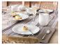 Elegante Tischdekoration mit weißem Porzellangeschirr, Sektgläsern und Desserts.