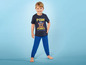 Junge in blauem Pyjama mit Paw Patrol-Motiv.