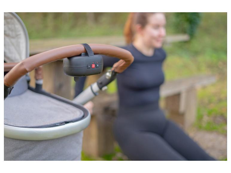 Frau trainiert draußen mit Kinderwagen und befestigtem ZAZU-Gerät.