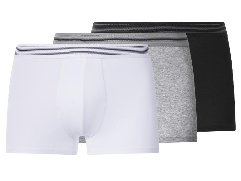 Drei Herren-Boxershorts in Weiß, Grau und Schwarz mit gestreiften Bund.