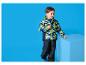 Junge in bunter Camouflage-Jacke und dunkler Hose an einem blauen Würfel.