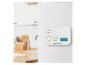 Weißer Gasmelder mit Digitalanzeige und Tasten, an einer weißen Wand in der Küche montiert.