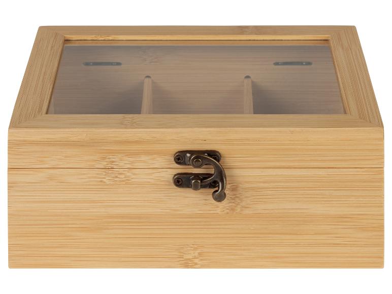 Eine Holzkiste für Tee mit Glasdeckel und Fächern für verschiedene Teesorten.