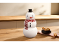 Schneemann-Keksdose mit Hut und Schal, daneben eine Schale mit Keksen auf einem Holztisch.