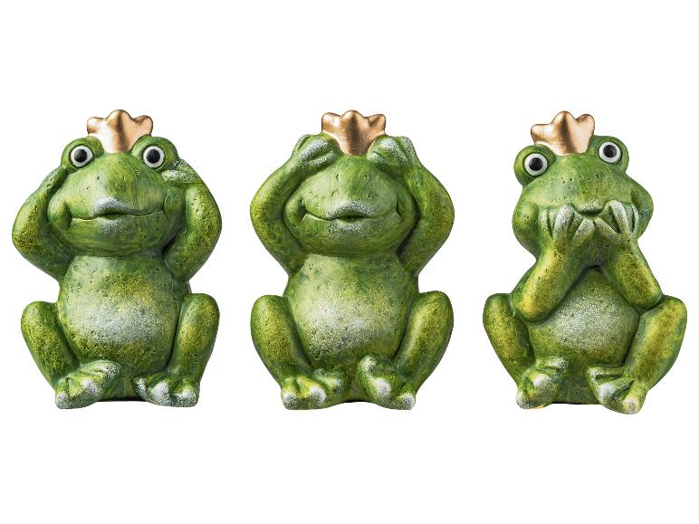 Drei grüne Froschfiguren mit goldenen Kronen, die „nichts hören, nichts sehen, nichts sagen“ darstellen