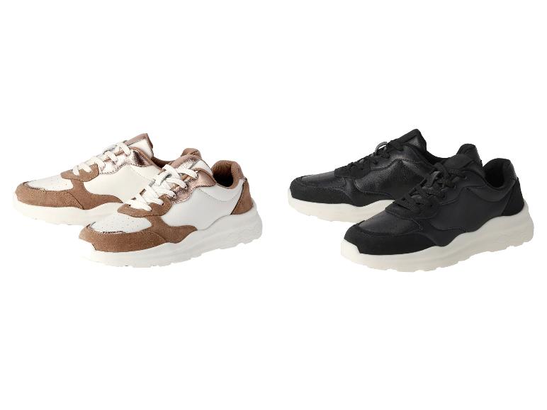 Weiße und schwarze Sneaker mit beigefarbenen Details.