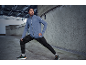 Mann dehnt sich in Steppjacke und Sporthose.