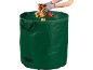 Grüner Gartenabfallsack mit Herbstlaub und behandschuhten Händen