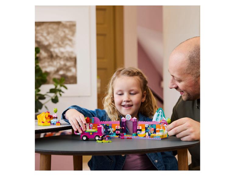 Lächelnder Vater und Tochter spielen mit einem bunten Bausatz.