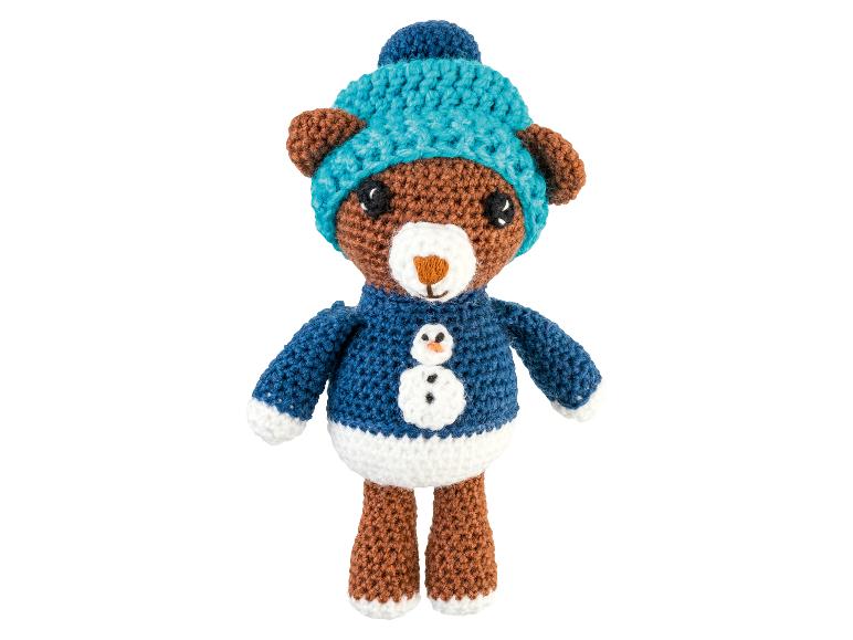 Gehäkelter Bär mit blauer Mütze und Pullover mit Schneemann.