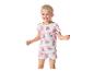 Lächelndes Mädchen in weißem Pyjama mit rosa Herzen und Welpenzeichnungen.