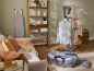 Wäscheständer mit Kleidung, Bügelbrett und Regal mit Wäscheartikeln im Wohnzimmer.