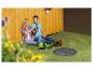 Paar entspannt auf dem Rasen mit Gartenstiefeln und einem Garten-Schachtabdeckung.