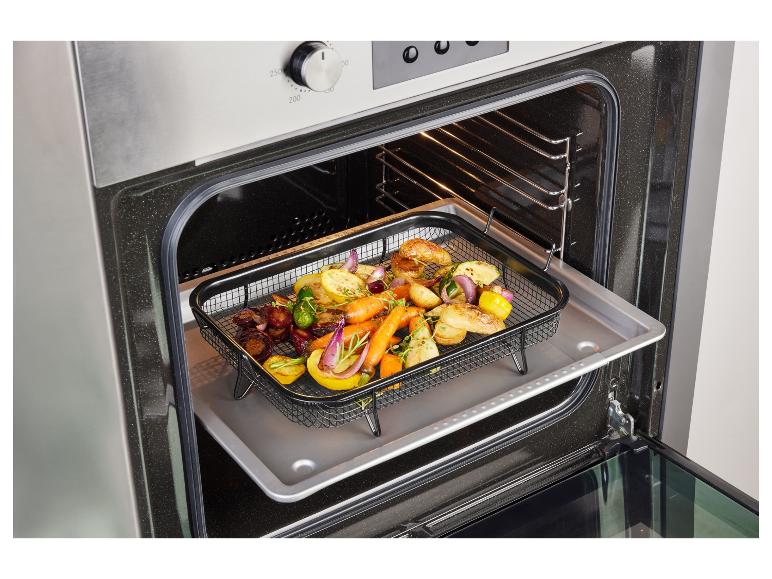 Ein Backofen mit einem Backblech und einem Rost mit gebratenem Gemüse.